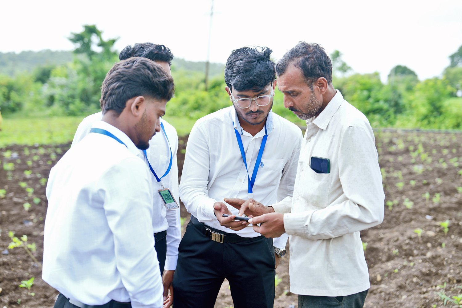 Glaubark field officers reviewing farm data with a farmer on a phone